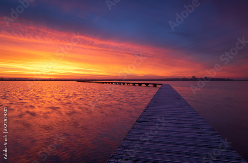 Very colorful and tranquil dawn at a jetty in a lake. Groningen  Holland.