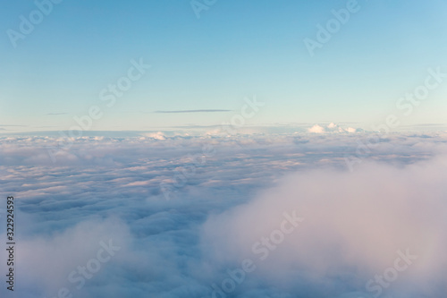 Aerial view of fluffy clouds through an airplane window