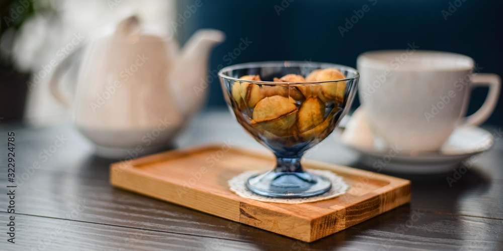 Russian walnut cookies stuffed with condensed milk in glass bowl in a restaurant with blurred background. Russian walnut cookies stuffed with condensed milk in glass bowl in a restaurant with blurred background.