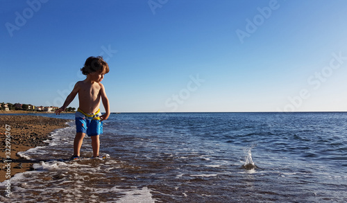 Small boy throw stones to sea