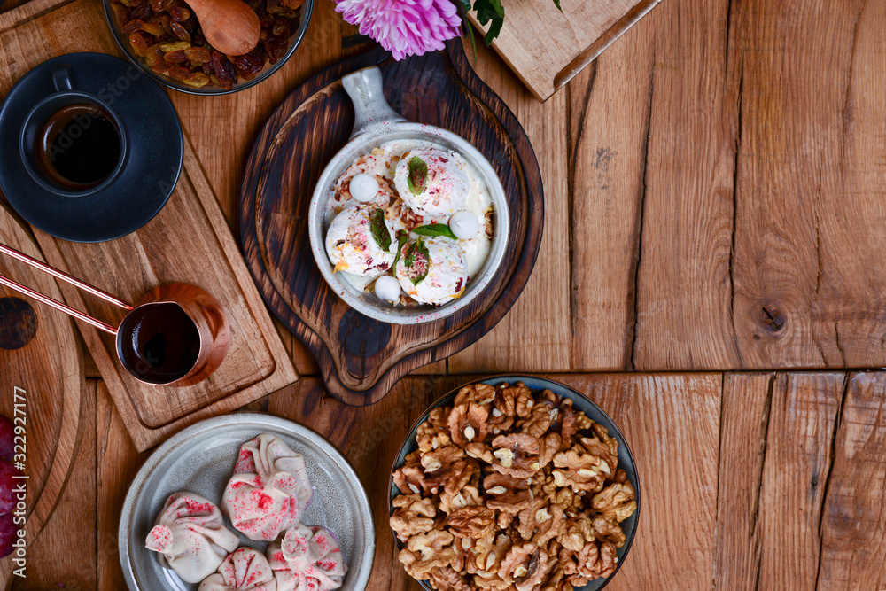 Sweet khinkali with cherry, churchhela, ice cream and nuts served on a wooden table. Traditional Georgian desserts