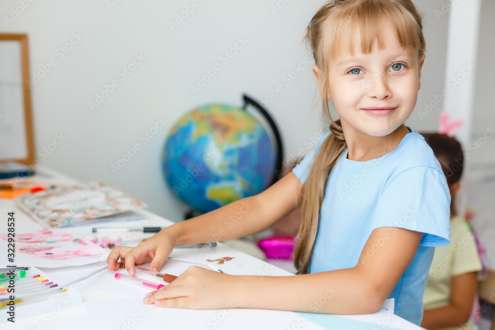 education, creation and school concept - smiling little student girl drawing and daydreaming at school education, creation and school concept - smiling little student girl drawing and daydreaming at school