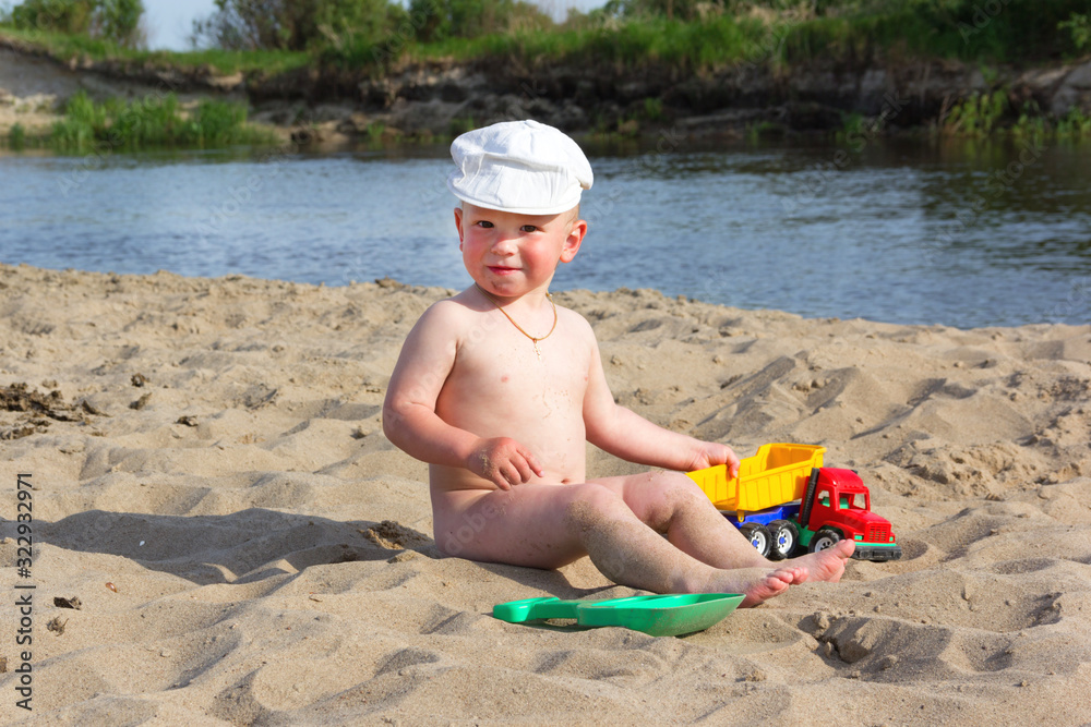 Cute baby boy playing with beach toys on tropical beach Cute baby boy playing with beach toys on tropical beach
