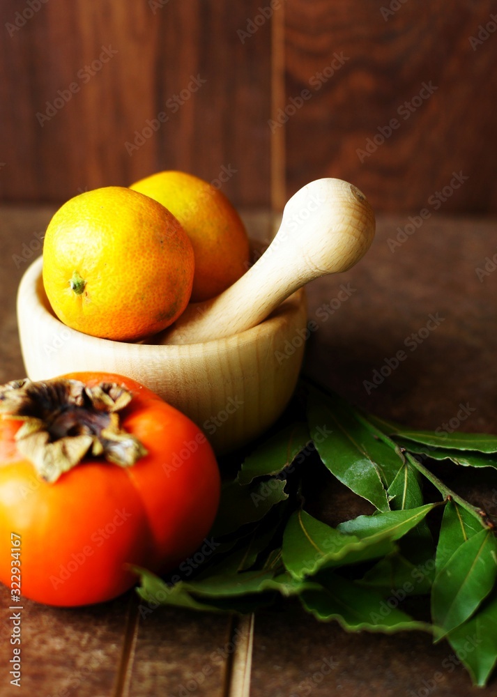 orange fruits, green leaves and wooden pounder