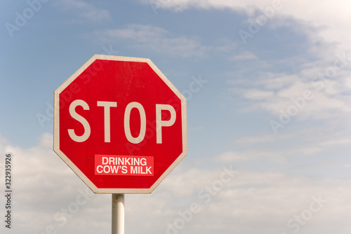 Traffic Stop sign altered, presumably by a vegan or vegetarian, with a sticker to read "Stop eating drinking cow's milk". In Auckland, New Zealand.