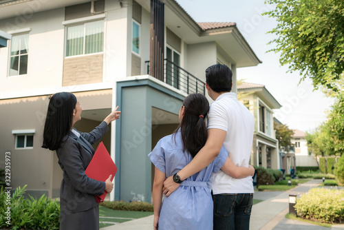 фотографія Asian woman Real estate broker agent showing a house project detail in her file to the young Asian couple lover looking and interest to buy it