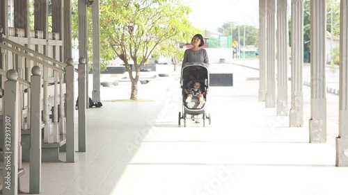  asian short hair woman take a walk with her baby inside the babystroller.mother and daughter concept photo