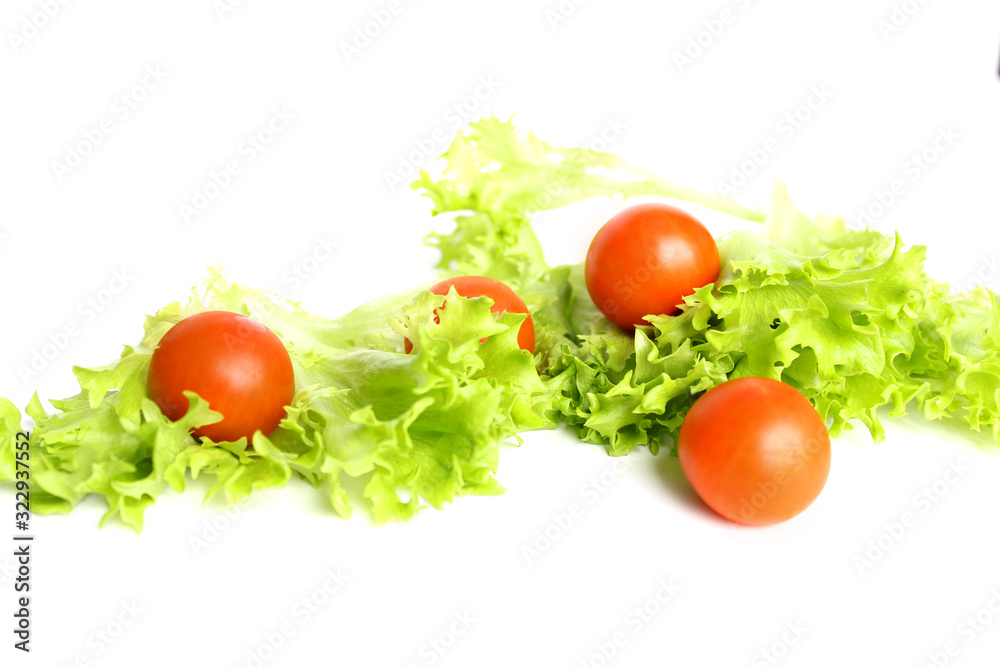 Red cherry tomatoes and lettuce leaves on white background Red cherry tomatoes and lettuce leaves on white background
