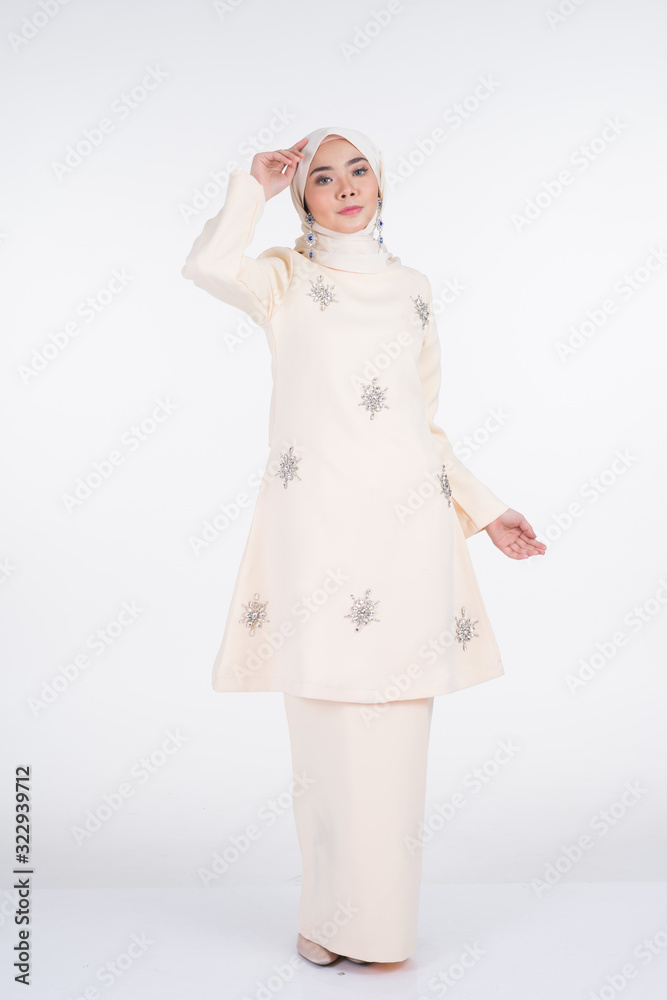 Beautiful female Muslim model in various poses wearing kurung Pahang and hijab, a lifestyle apparel for Muslim women isolated on white. Beauty and hijab fashion concept. Full length portrait Beautiful female Muslim model in various poses wearing kurung Pahang and hijab, a lifestyle apparel for Muslim women isolated on white. Beauty and hijab fashion concept. Full length portrait
