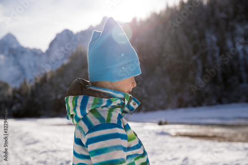 Sun flared of boy enjoying his free time in the snow photo