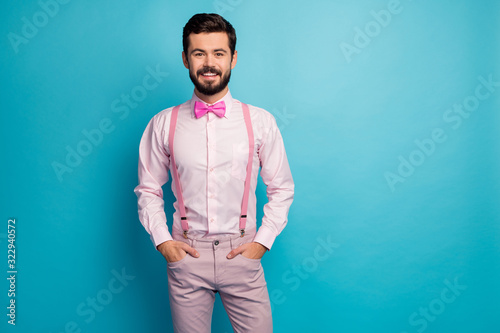 Portrait of charming satisfied guy put hands pocket enjoy spring free time wear stylish trendy clothes isolated over blue color background