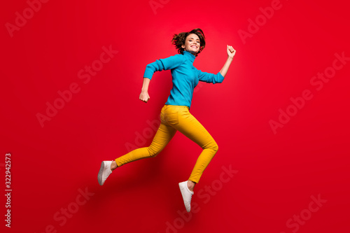 Full size profile side photo of cute charming candid girl jump run after black friday bargain wear casual style clothing isolated over vibrant color background