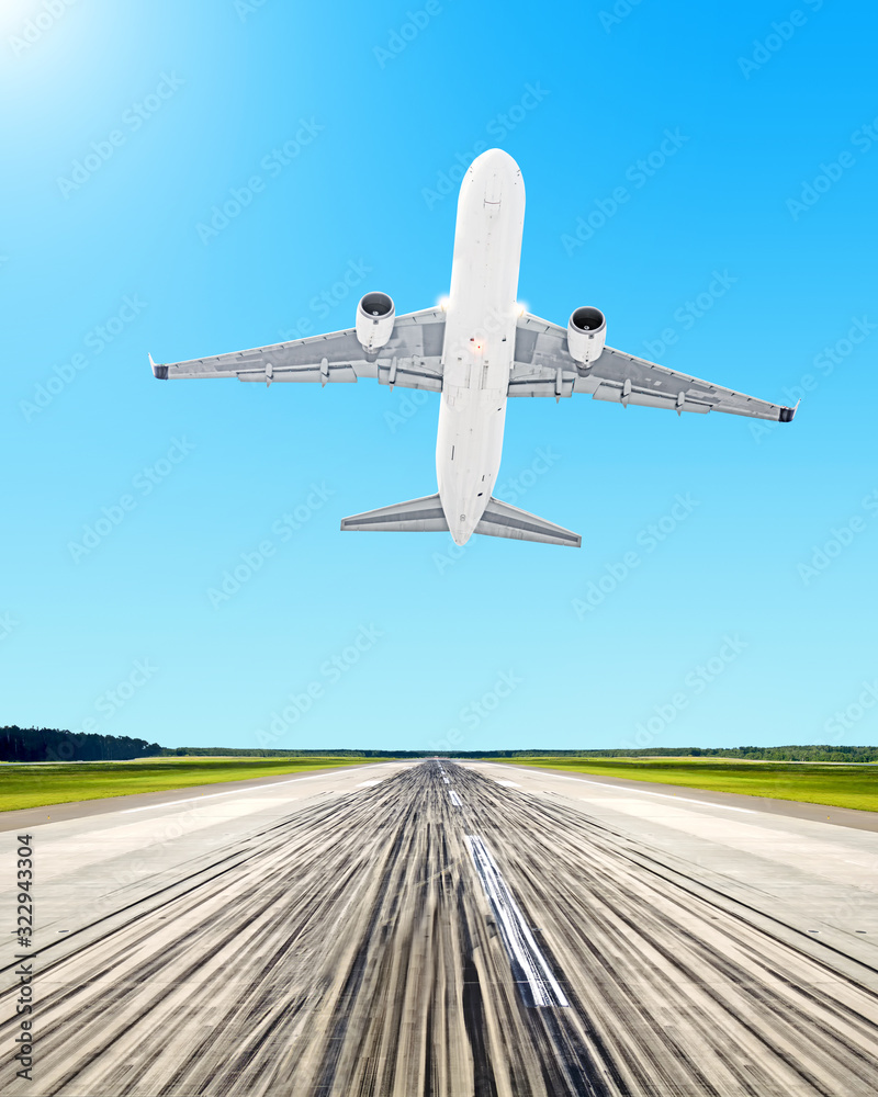 modern airplane take off from airport runway against blue sky background. Front vertical ground view of white passenger plane flying. Jet aircraft departure landscape scene portrait orientation photo modern airplane take off from airport runway against blue sky background. Front vertical ground view of white passenger plane flying. Jet aircraft departure landscape scene portrait orientation photo
