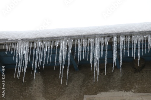 Big icicles and snow hanging over the rain gutter on a roof of a traditional wooden house in the mountains in winter could be dangerous.artvin turkey