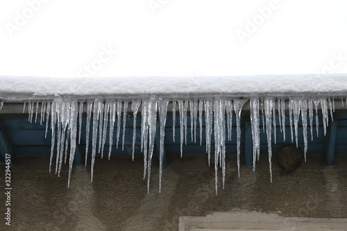 Big icicles and snow hanging over the rain gutter on a roof of a traditional wooden house in the mountains in winter could be dangerous.artvin turkey