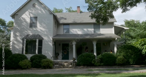 Establishing shot of a large two story home during the summer - dolly shot