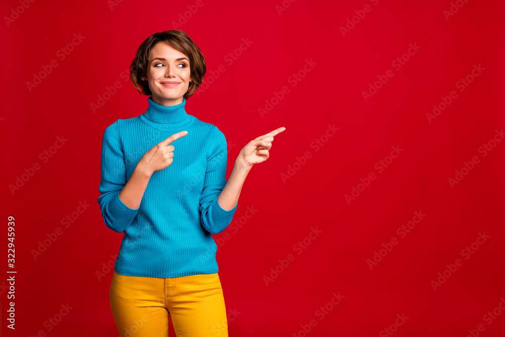 Portrait of positive cheerful girl promoter point index finger look copyspace indicate ads promotion recommend direct way wear stylish clothes isolated over red color background Portrait of positive cheerful girl promoter point index finger look copyspace indicate ads promotion recommend direct way wear stylish clothes isolated over red color background