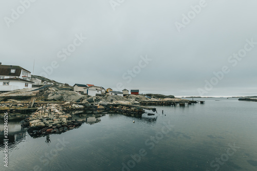 Vrångö, Southern Gothenburg Archipelago / Sweden -  A view of sea shore, a rocky landscape of Vrångö island and its scandinavian wooden houses in Sweden during a cloudy day.