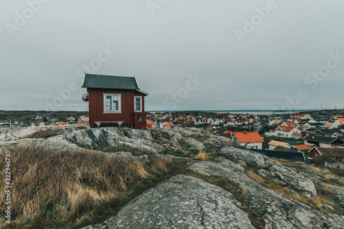 A view of the former red scandinavian harbour pilot house, and rocky landscape Vrångö island belonging to Gothenburg archipelago, Sweden during a cloudy day.