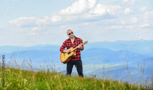 Music for soul. Playing music. Sound of freedom. Hiker enjoy nature. Acoustic music. Musician hiker find inspiration in mountains. Keep calm and play guitar. Man hiker with guitar on top of mountain