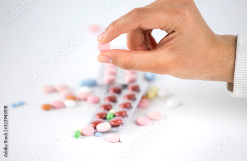Multicolored medical capsule , holding pills in women hands.