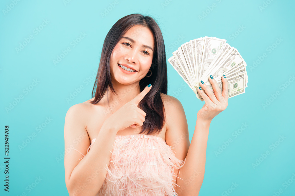 Smiling face portrait asian beautiful woman cheerful her holding and point the money Smiling face portrait asian beautiful woman cheerful her holding and point the money