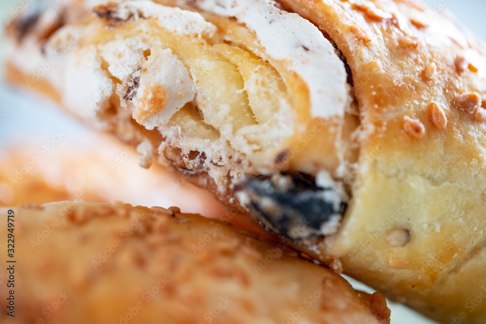 Fresh and rouge rolls with nuts, raisins and meringues on a wooden table and a cup with aromatic coffee