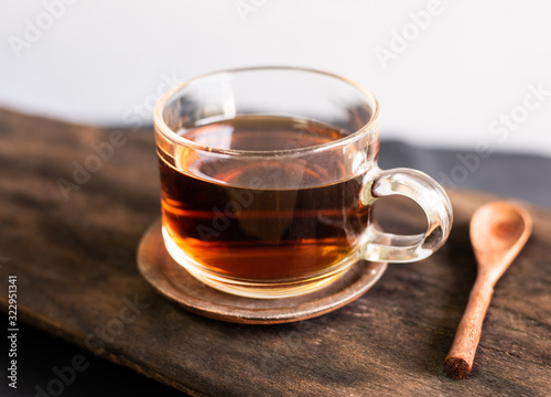 Hot tea with spoon wood on woo table.