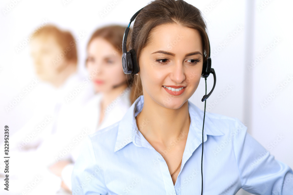 Call center. Focus on beautiful business woman using headset in sunny office Call center. Focus on beautiful business woman using headset in sunny office