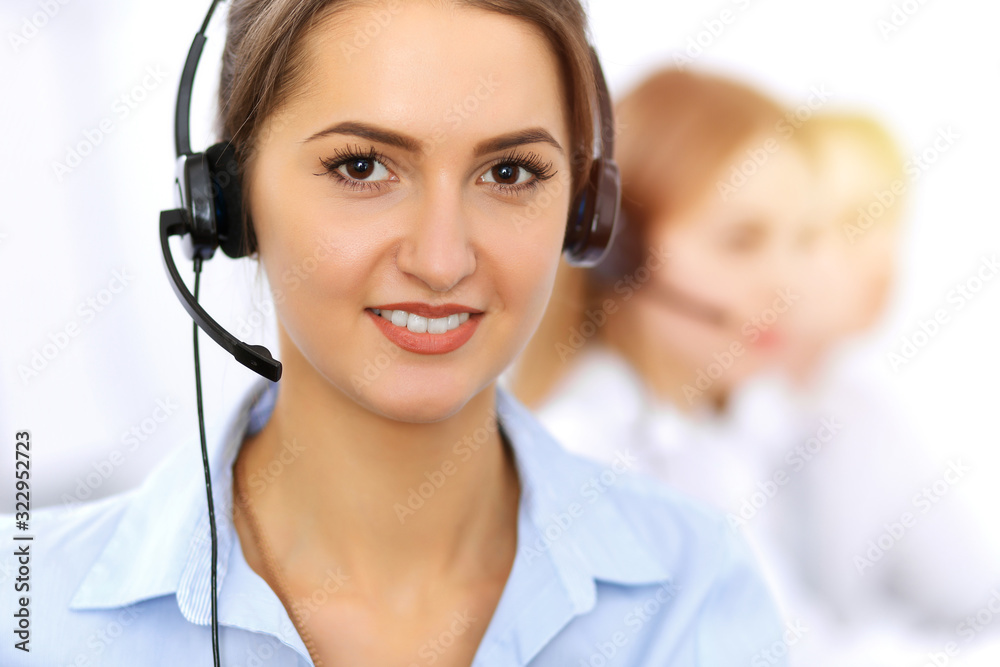 Call center. Focus on beautiful business woman using headset in sunny office Call center. Focus on beautiful business woman using headset in sunny office