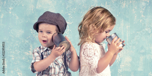 Kinder spielen - telefonieren mit Blechdosen photo