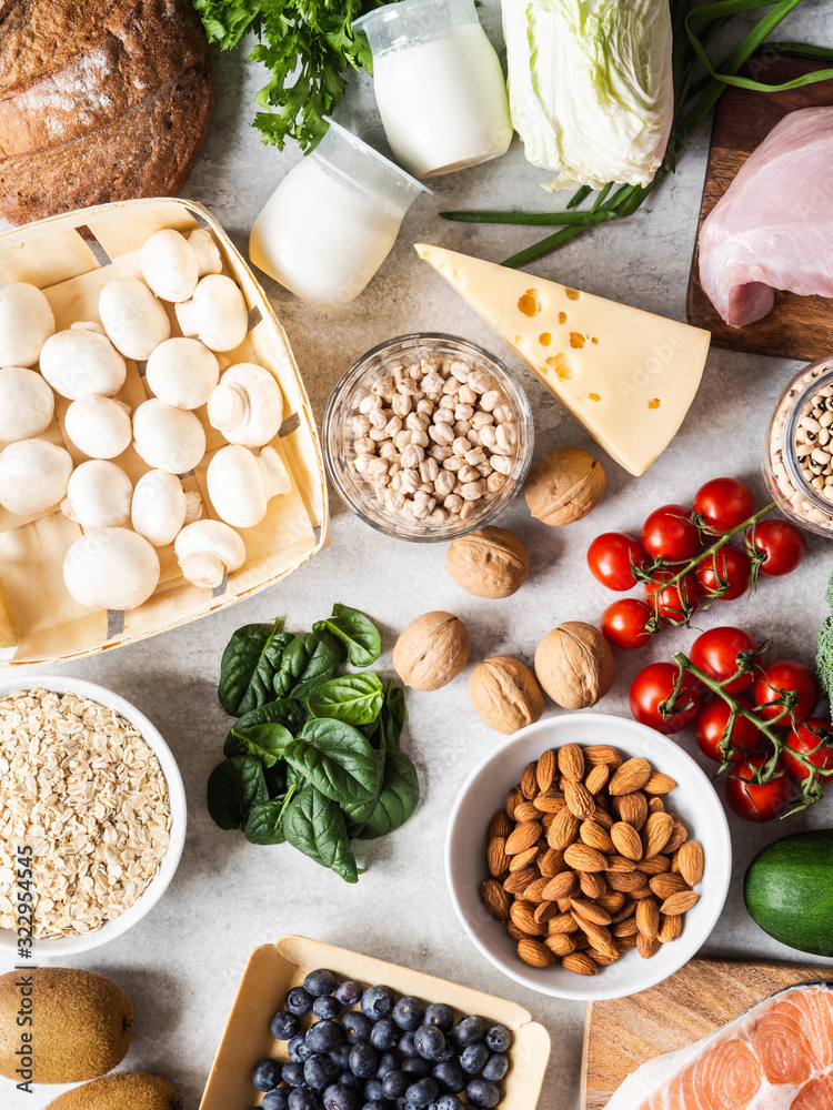 Healthy balanced ingredients background. Flat lay of fruits, vegetables, dairy products, cereals, legumes, dietary meat and fish, nuts and seeds on the table. Top view. Balanced healthy food concept