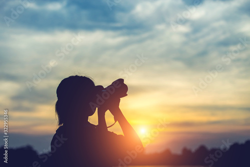 Silhouette women Nature photographer with digital camera on the mountain and lake © Janpen