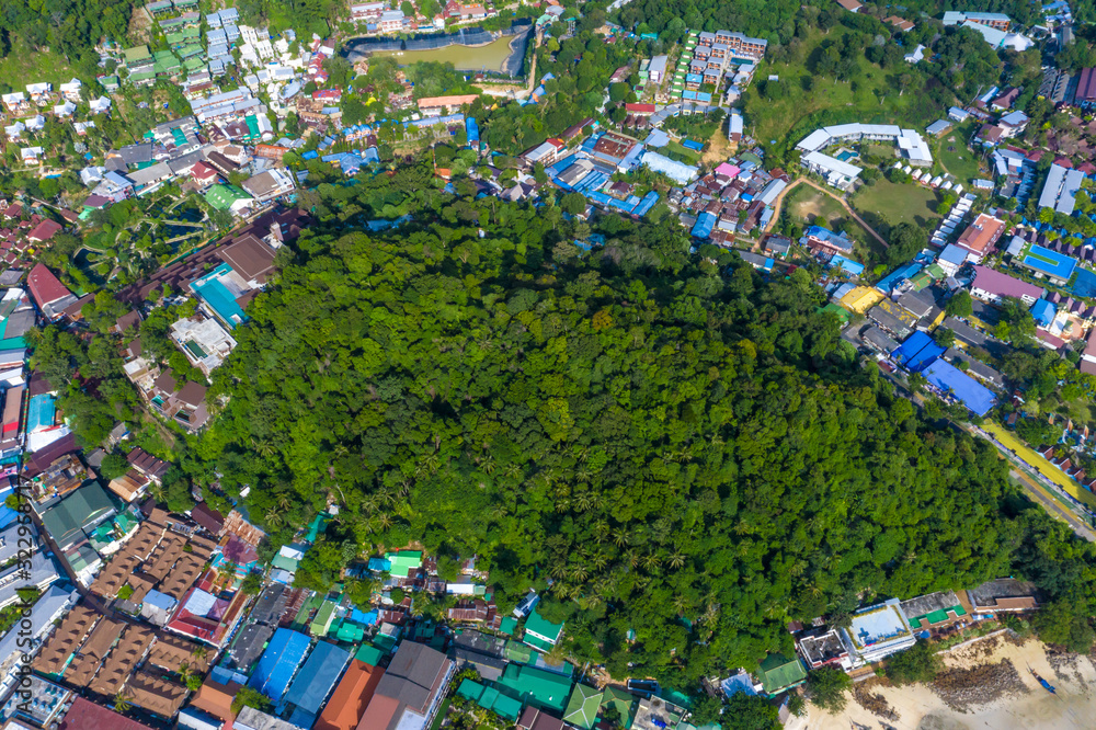 Flying over a busy paradise island harbor on a beautiful summer day. Remote harbor village is swarmed by tourist boats going on spectacular sightseeing trips around idyllic Phi Phi Islands.