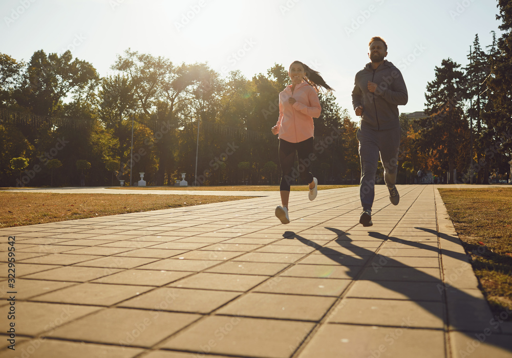 Φωτογραφία Sporty couple are running along the city street in the morning.