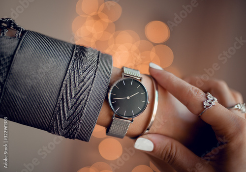 Stylish black watch with silver strap on woman hand