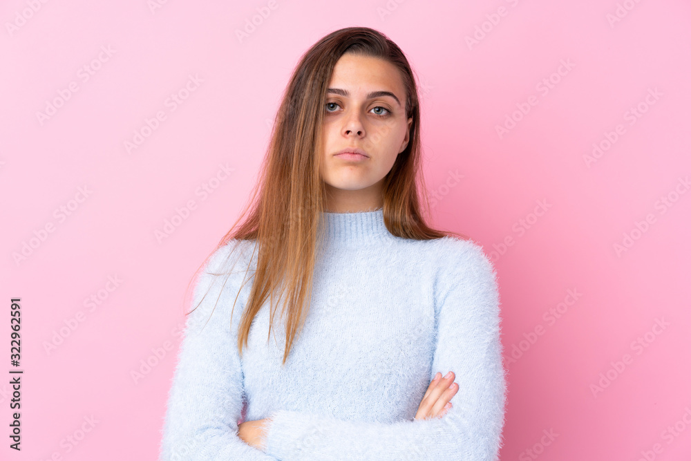 Teenager girl with blue sweater over isolated pink background keeping arms crossed Teenager girl with blue sweater over isolated pink background keeping arms crossed