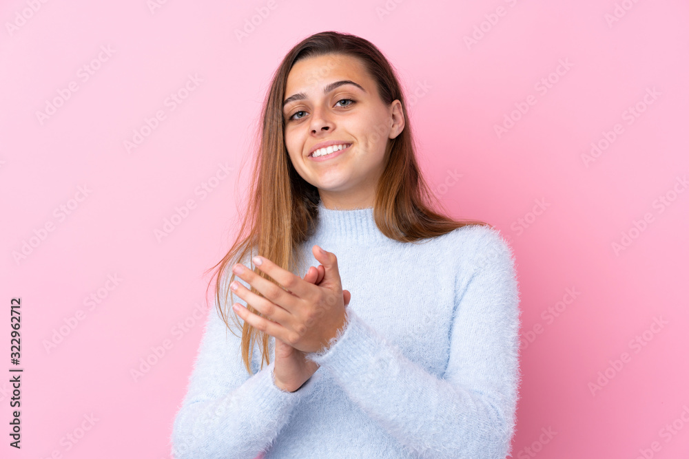 Teenager girl with blue sweater over isolated pink background applauding Teenager girl with blue sweater over isolated pink background applauding