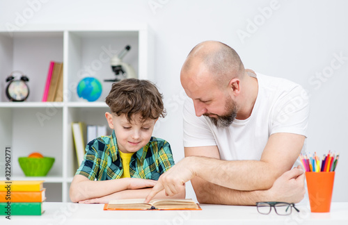 Father and his son doing homework together at home
