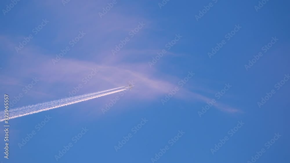A flight flies heaven high through the frame leaving turbulent wake in the sky A flight flies heaven high through the frame leaving turbulent wake in the sky