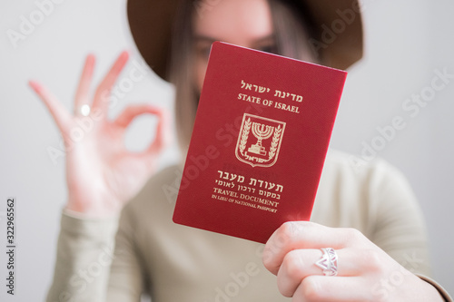 Woman with Israel travel document passport on white background girl making OK sign. immigration, travel concept
