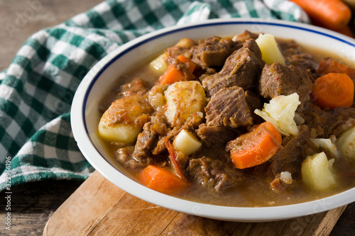 Irish beef stew with carrots and potatoes on wooden table
