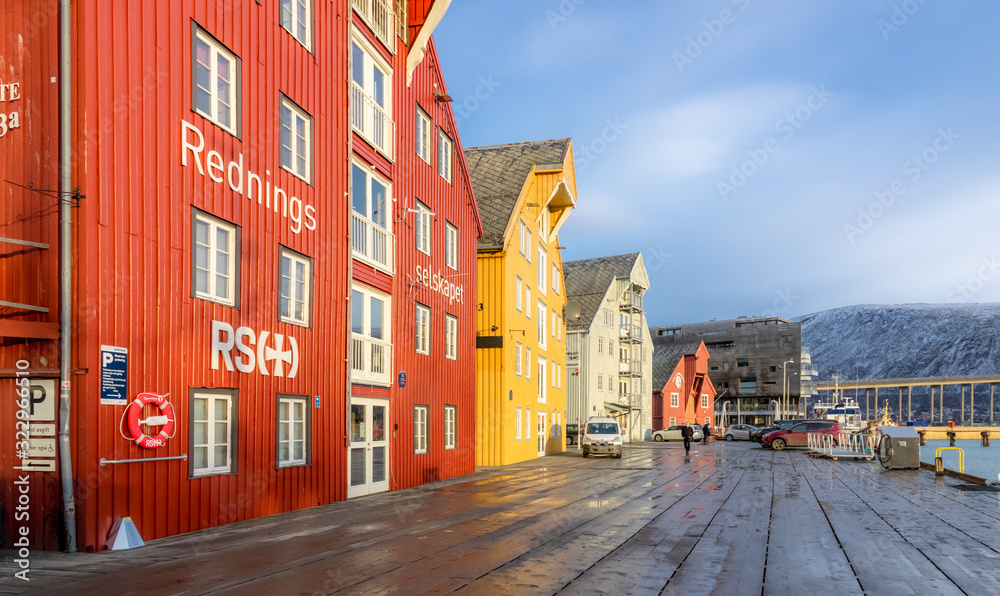 Wooden quay and colourful houses in Tromsø. Visit with Hurtigruten.