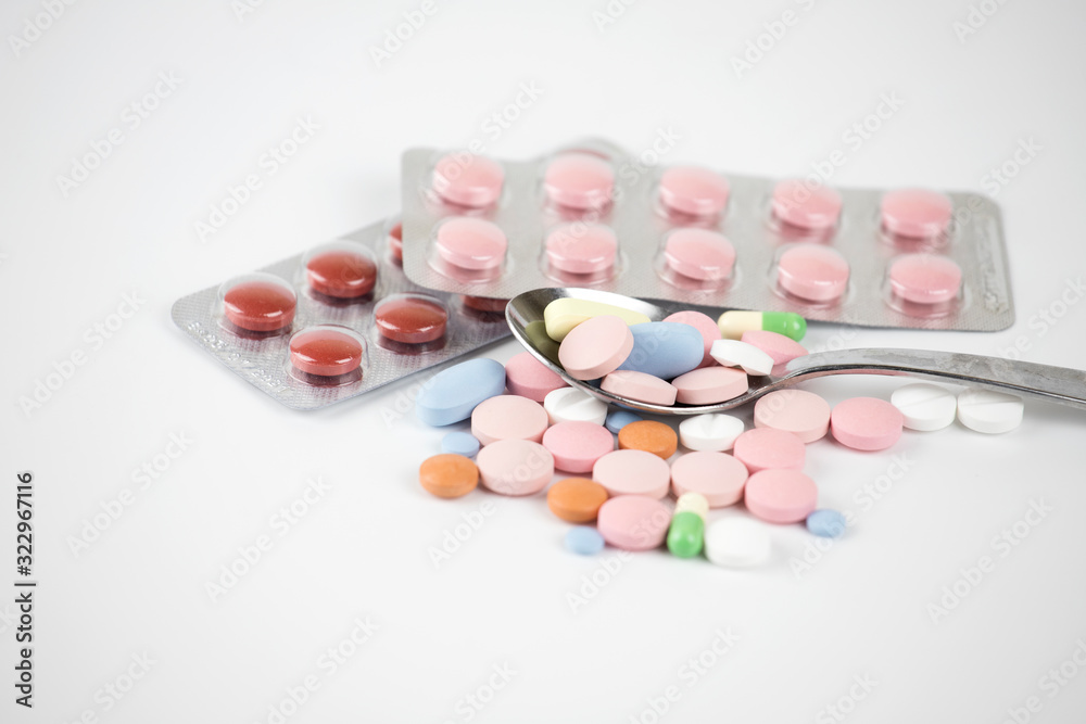 Multi-colored medical capsules, a spoonful of pills and capsules