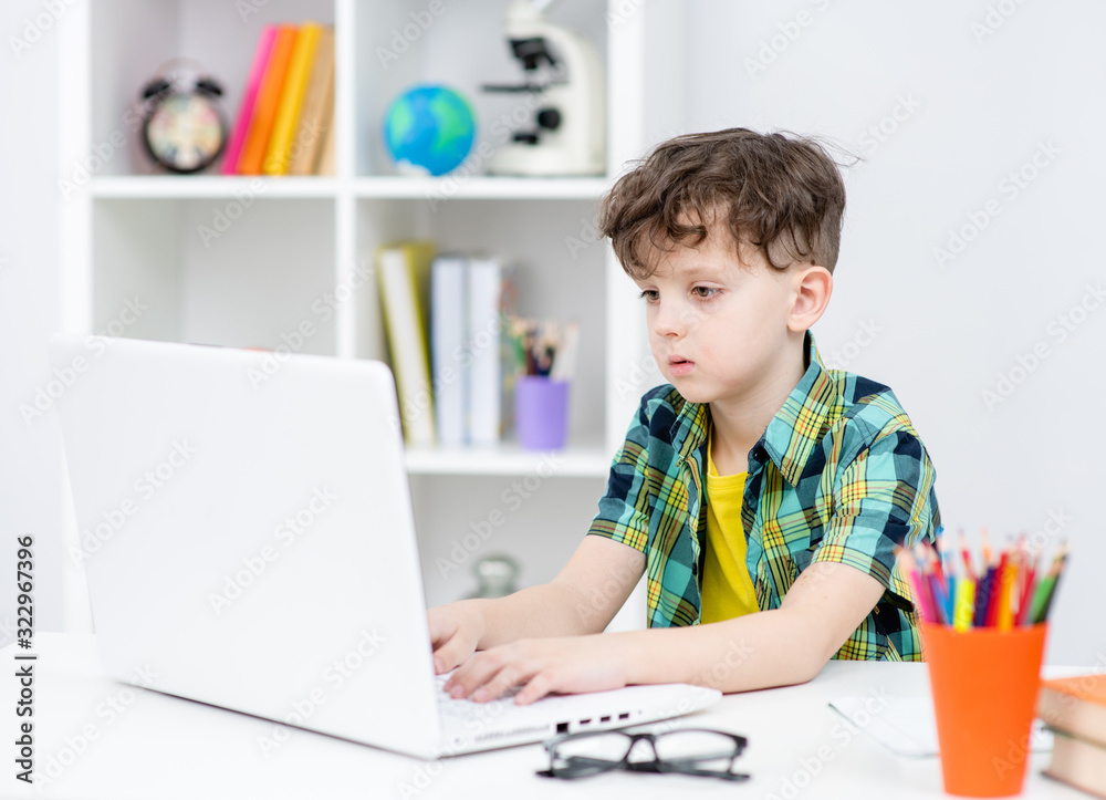 Young boy uses laptop at home Young boy uses laptop at home