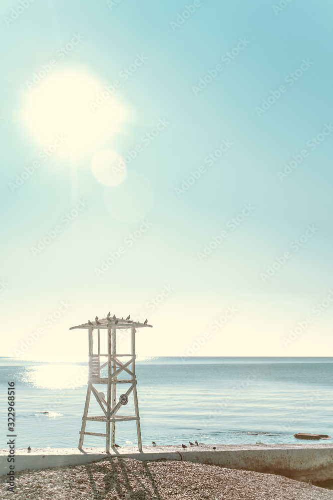 Lifeguard tower on a deserted beach against the blue morning sky