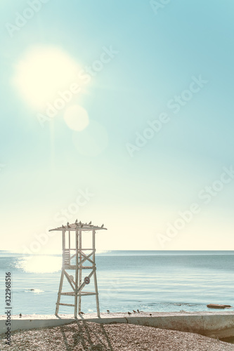 Lifeguard tower on a deserted beach against the blue morning sky