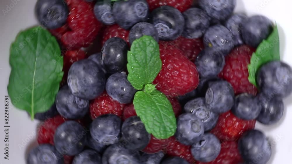 Mix of fresh blueberries and raspberries with fresh mint leaves, rotation in a circle. Mix of fresh blueberries and raspberries with fresh mint leaves, rotation in a circle.