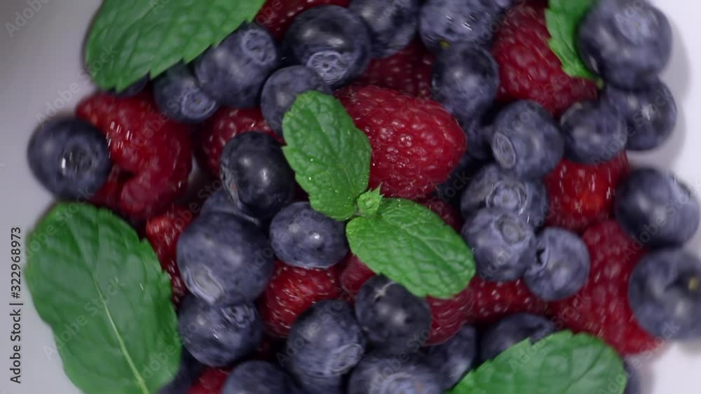 Mix of fresh blueberries and raspberries with fresh mint leaves, rotation in a circle. Mix of fresh blueberries and raspberries with fresh mint leaves, rotation in a circle.