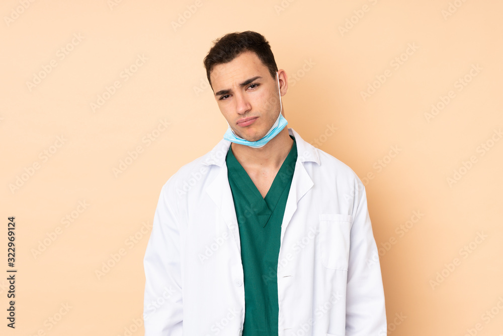Young dentist man holding tools isolated on beige background with sad and depressed expression Young dentist man holding tools isolated on beige background with sad and depressed expression